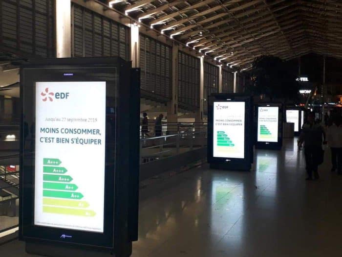 Une publicité EDF qui incite à réduire sa consommation d'énergie en utilisant des écrans lumineux alors que de simples affiches auraient suffies.